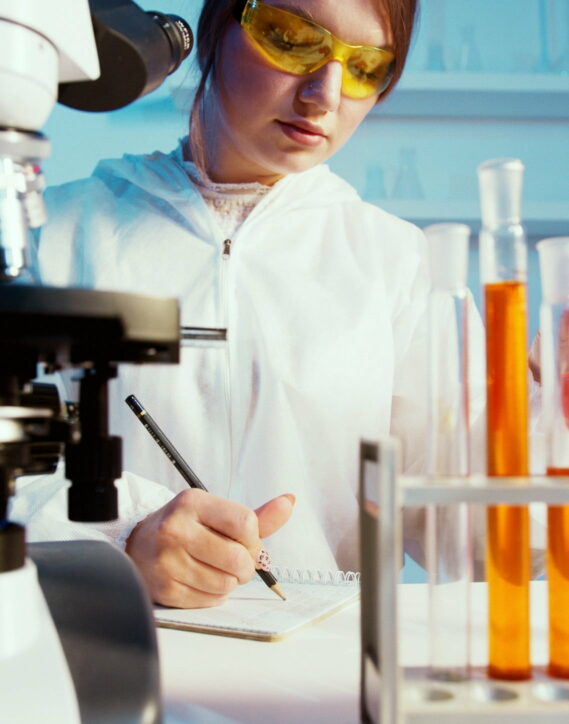 Frau beim erfassen von Notizen in Chemie-Labor
