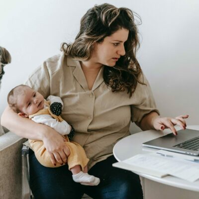 Frau mit Baby und Laptop