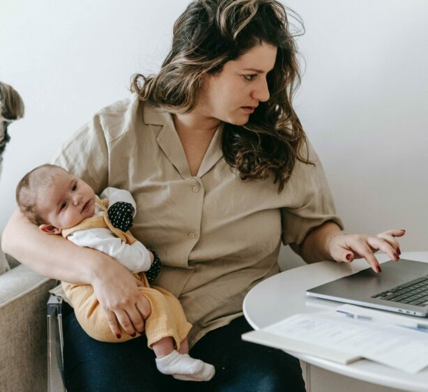 Frau mit Baby und Laptop