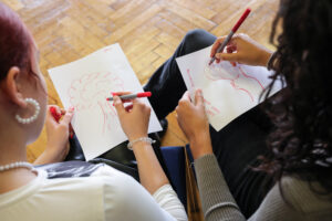 Blick auf Papier, zwei Schülerinnen zeichnen