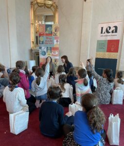 Lesung des LEA-Kinderbuches "Wer macht MINT?", Mädchen zeigen auf, Autorin lacht